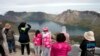 In this Saturday, Aug. 18, 2018, photo, Chinese tourists take in the sight from a viewing platform overlooking the caldera of Mount Paektu near Samjiyon in North Korea. 