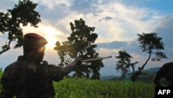 Umusirikare wa M23 yerekana aho bari bigaruriye ku musozi wa Kavumu mu ntara ya Kivu ya Ruguru. Hari taliki 3/6/2012 izo nyeshyamba zitaratsindwa ngo zihungire mu bihugu bituranye na Kongo.