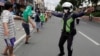 A traffic officer instructs jobless jeepney drivers to practice social distancing as they line up to receive food donations during the lockdown in Quezon city, Philippines on Aug. 7, 2020. 