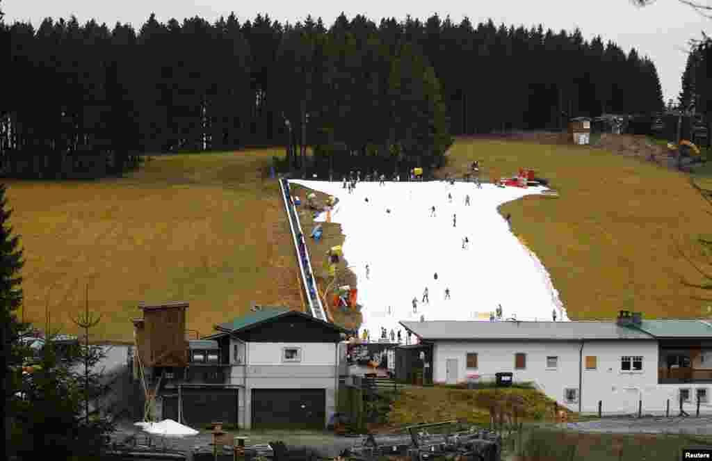 Visitors ski on a piste made with artificial snow on a warm day in the western German ski resort of Winterberg, some 80km southeast of Dortmund.