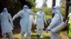 FILE - Health workers wearing protective suits prepare to bury coronavirus victim Dr. Doreen Adisa Lugaliki, at her funeral in Ndalu, Bungoma county, Kenya, July 13, 2020.