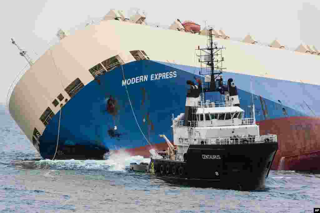 In this photo provided by the Prefecture Maritime Atlantique, the 164-meter (538-foot) cargo ship Modern Express is towed as it drifts off the coast of France. The ship had been adrift for five days in southwest France.