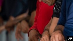 Migranti čekaju na Gateway International Port of Entry pod pritvorom američke carine i granične zaštite u Brownsvilleu, Teksas, u petak, 5. maja 2023., prije nego što budu vraćeni u Meksiko. (AP Photo/Veronica G. Cardenas) ​