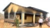FILE - Security officers and residents assess the damage at Arabia Boys Secondary School after suspected al-Shabaab militants threw an explosive device at a teacher's house in Mandera county, Kenya, Oct. 10, 2018. 