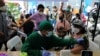 Seorang tenaga medis melakukan pemeriksaan kesehatan terhadap seorang perempuan yang akan menerima dosis vaksin booster COVID-19 di Jakarta, 12 Januari 2022. (Foto : REUTERS/Willy Kurniawan)