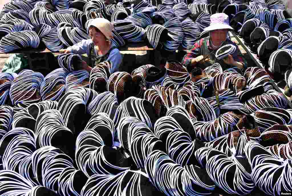 Para karyawan sibuk mengerjakan sepatu kain tradisional di Yiyuan County, Provinsi Shandong, China, 2 Mei 2017.