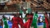 FILE - A player from Kano Pillars, center, in green and white, jumps to make a basket, challenged by Mark Mentors players in red and black, during Nigeria's Final Four in Lagos, Nigeria, Sept. 5, 2013.