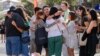 A group of people react after placing flowers as a tribute near a crime scene at Bondi Junction in Sydney, April 15, 2024, after several people were stabbed to death at a shopping on April 13. 
