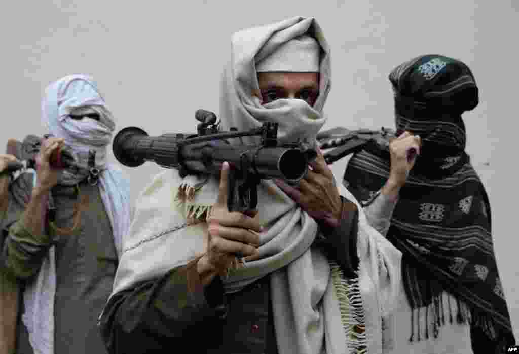 Former Afghan Taliban fighters carry their weapons before handing them over as part of a government peace and reconciliation process at a ceremony in Jalalabad. More than a dozen former Taliban fighters from Ghani district of Nangarhar province handed over their weapons as part of the&nbsp; program.