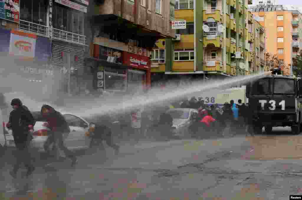 Turkish riot police use a water cannon to disperse Kurdish demonstrators during a protest in the southeastern city of Diyarbakir, against a curfew in Sur district and security operations in the region.