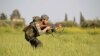 FILE - A rebel fighter is seen aiming his weapon in the countryside near Aleppo, Syria.