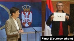 Poslanik Ekološkog ustanka Aleksandar Jovanović drži natpis "laže" na konferenciji za medije predsednice Narodne Skupštine Ane Brnabić (Zoran Mrđa / Fonet)