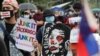 A protester holds a caricature of Philippine President Rodrigo Duterte during an anti-terror bill rally at the University of the Philippines in Manila, Philippines as they observe Philippine Independence Day on Friday, June 12, 2020.
