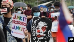 A protester holds a caricature of Philippine President Rodrigo Duterte during an anti-terror bill rally at the University of the Philippines in Manila, Philippines as they observe Philippine Independence Day on Friday, June 12, 2020.