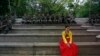 A woman in a traditional Korean Hanbok costume sits in front of South Korean soldiers at Namsangol Hanok Village in Seoul, May 20, 2013. 