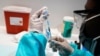 FILE- A health care worker fills a syringe with the Pfizer COVID-19 vaccine, at the American Museum of Natural History in New York, July 22, 2021.