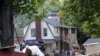 Homeowners clean debris from their property caused by Tropical Storm Irene in the Town of Keene , N.Y., Monday, Aug. 29, 2011. Tropical Storm Irene left stunned upstate New Yorkers shaking their heads Monday at a crippling wallop they never thought possib