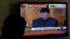 A man looks at a television screen displaying cricketer-turned-politician Imran Khan being sworn in as prime minister of Pakistan, in Karachi, Pakistan, Aug. 18, 2018.