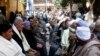 Neighbors and friends of relatives of the Egyptian Coptic men killed in Libya sit at the courtyard of the Virgin Mary Church in the village of el-Aour, near Minya, 220 kilometers (135 miles) south of Cairo, Egypt, Feb. 16, 2015.