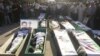 Syrian residents gather in front of the bodies of people, whom protesters say were killed by forces loyal to Syria's President Bashar al-Assad, during their funeral in Dara'a June 9, 2012. 