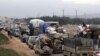 FILE - A general view of vehicles carrying belongings of internally displaced Syrians from western Aleppo countryside, in Hazano near Idlib, Syria, Feb. 11, 2020.