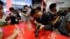 FILE - Visitors try out modern weapons during an exhibition of police equipment and anti-terror technologies held in Beijing.