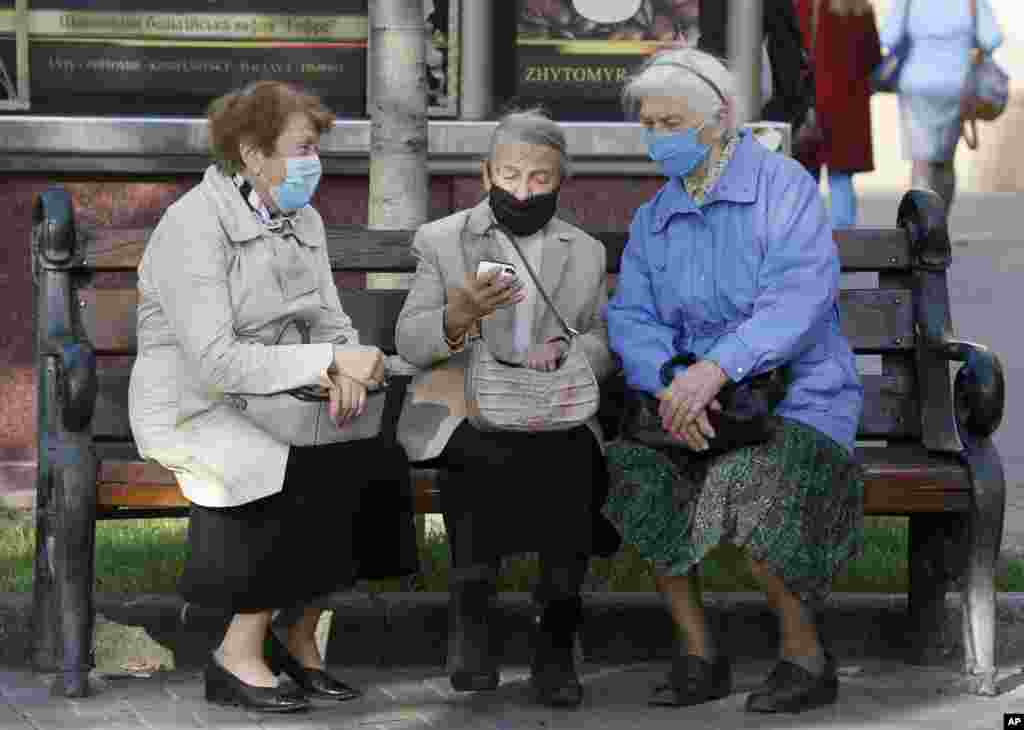 Elderly women look at a phone on a bench in capital Kyiv&#39;s main Khreshchatyk Street, Ukraine.