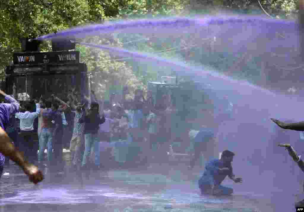 គ្រូបង្រៀន​ របស់​រដ្ឋាភិបាល Kashmir ស្រែក​ពាក្យស្លោក​ប្រឆាំង​នឹង​រដ្ឋាភិបាល​ខណ​ដែល​ប៉ូលិស​ឥណ្ឌា​បាញ់​ទឹក​ពណ៌ស្វាយ​នៅ​ក្នុង​បាតុកម្ម​ក្នុង​ទីក្រុង​ Srinagar ប្រទេស​ឥណ្ឌា។