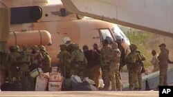 FILE - This undated photograph released in April 2022 by France's military shows Russian mercenaries boarding a helicopter in northern Mali. 