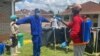 A health official sprays a colleague with a disinfectant Feb. 18, 2021, at Wilkins Hospital in Harare, where Zimbabwe launched its COVID-19 vaccination program. (Columbus Mavhunga/VOA)