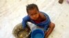 FILE - A Congolese child eats a meal at a UNHCR reception center at the Kyangwali refugee camp, Uganda, March 19, 2018. 
