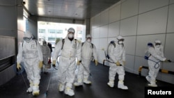 Workers from a disinfection service company sanitize a branch of the Shincheonji Church of Jesus the Temple of the Tabernacle of the Testimony where a woman known as "Patient 31" attended a service in Daegu, South Korea, February 19, 2020. Yonhap…