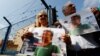 FILE - Demonstrators hold banners with the picture of Erol Onderoglu, local representative of Reporters Without Borders, during a protest against the arrest of three prominent activists for press freedom, in front of Metris prison in Istanbul, Turkey, June 24, 2016.