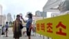 지난 8월 북한 평양역 입구에서 역무원이 신종 코로나바이러스 방역을 위해 승객들의 체온을 재고 있다.