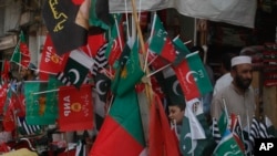 Flags of political parties are on sale ahead of elections, in Peshawar, Pakistan, Friday, July 20, 2018. 
