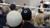 FILE - Two men wearing skullcaps as they listen to the speech of Israeli Historian Saul Friedlaender, during a remembrance event of the parliament Bundestag to commemorate the victims of the Holocaust at the Reichstag building in Berlin, Germany, Jan. 31, 2019.
