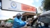 FILE - A health worker screens and sanitizes visitors to prevent the spread of coronavirus disease (COVID-19) outside a hospital in Harare, Zimbabwe, March 26, 2020. 