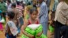 A newly arrived Rohingya girl carries food rations in Kutupalong, Bangladesh, Saturday, Sept. 30, 2017. 