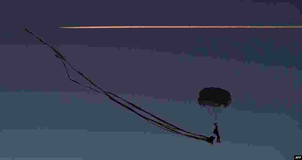 A paraglider prepares to land at dusk, prior to the contests at the Four-Hills Ski Jumping Tournament in Oberstdorf, southern Germany, Dec. 28, 2015.