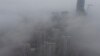 Buildings are seen shrouded in heavy haze at Qingdao development zone, Shandong province, Feb. 25, 2014. 