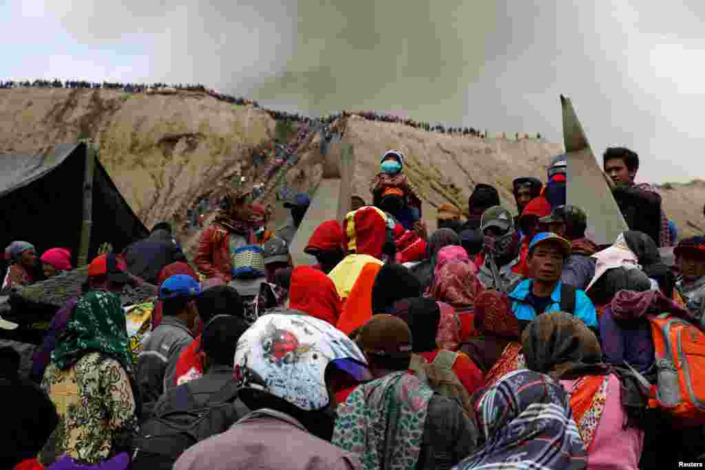 Gunung Bromo memuntahkan abu vulkanik sementara warga Hindu dan pengunjung menunggu peringatan tradisional Kasada, di mana warga melempar barang dan makanan sebagai sesaji ke kawah Bromo, di Probolinggo, Jawa Timur.