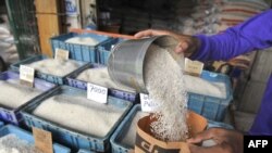 Seorang pedagang beras eceran di Jakarta, tengah memasukkan beras ke dalam kantong kertas di tokonya, 4 Februari 2011. (AFP PHOTO / ROMEO). 