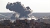 Smoke rises over the Syrian city of Kobani, following a US led coalition airstrike, seen from outside Suruc, on the Turkey-Syria border, Nov. 10, 2014. 