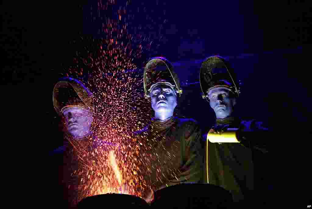 Blue Man Group performs during a media preview in Singapore where they will start their world tour to mark the founding of their group 25 years ago.