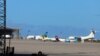 FILE - Airplanes are seen at Mitiga airport, in Tripoli, Libya, April 8, 2019. A large group of African migrants were flown out this week from Libya to their home countries. 