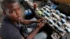 FILE - Jamil Idriss charges 50 naira ($0.33) to recharge phone batteries using rows of three-pin sockets nailed to a plank of wood and plugged into a diesel generator in the Obalende district of Lagos, Nigeria, May 20, 2010. 