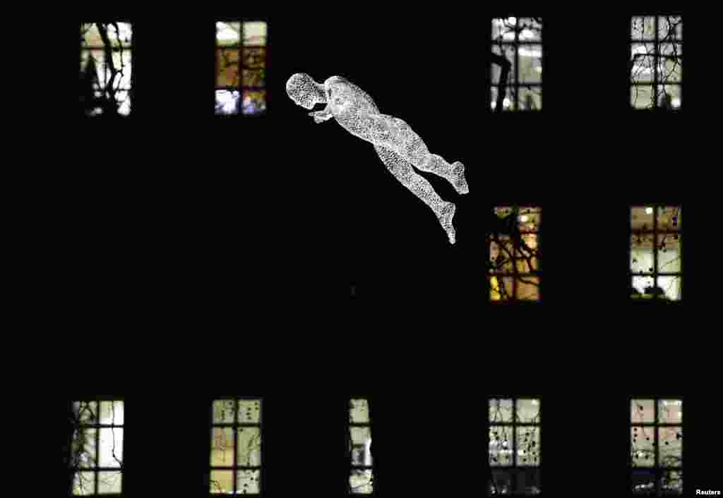 An illuminated section of "The Travellers" by Cedric Le Borgne is seen suspended above St. James's Square as part of the "Lumiere" festival in London, Jan. 14, 2016. The event, which takes place over four evenings, displays the illumination of famous landmarks and artworks by international artists.