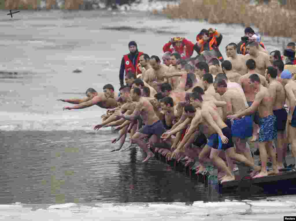 Men jump into the waters of a lake in an attempt to grab a wooden cross on Epiphany Day in Sofia, Bulgaria.