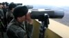 South Korean soldiers look at North Korea through binoculars from Dora Observation Post near the border village of Panmunjom, April 10, 2013.