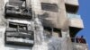 Two men stand on the balcony of a buildling reportedly targeted by Israeli air strikes in the Syrian capital Damascus on Feb. 21, 2024.